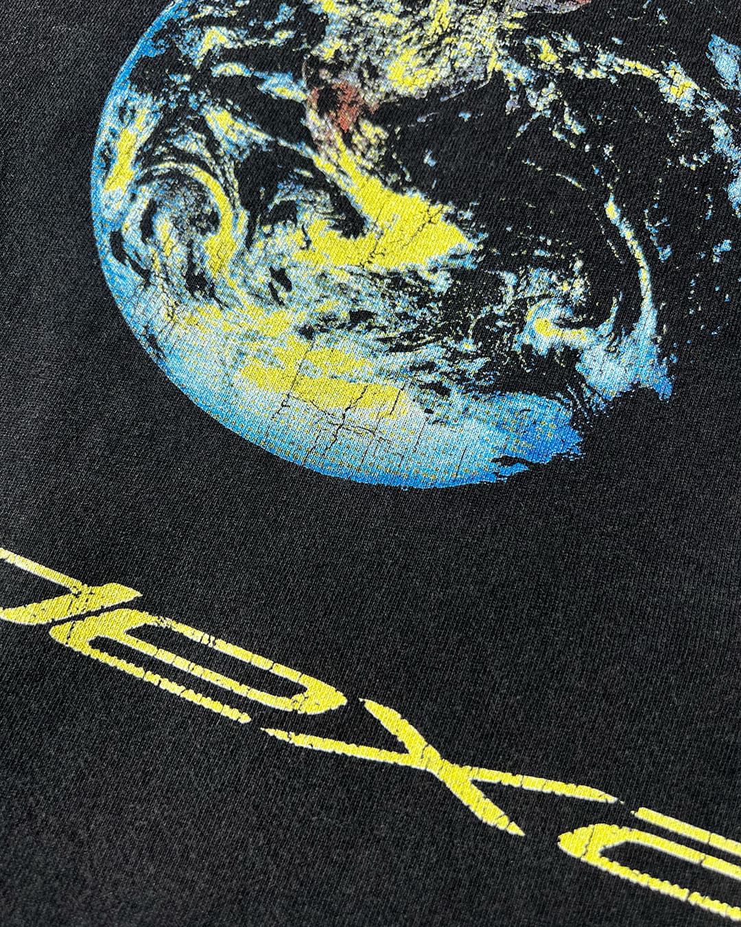 Close-up of earth graphic and yellow ODEXA text print