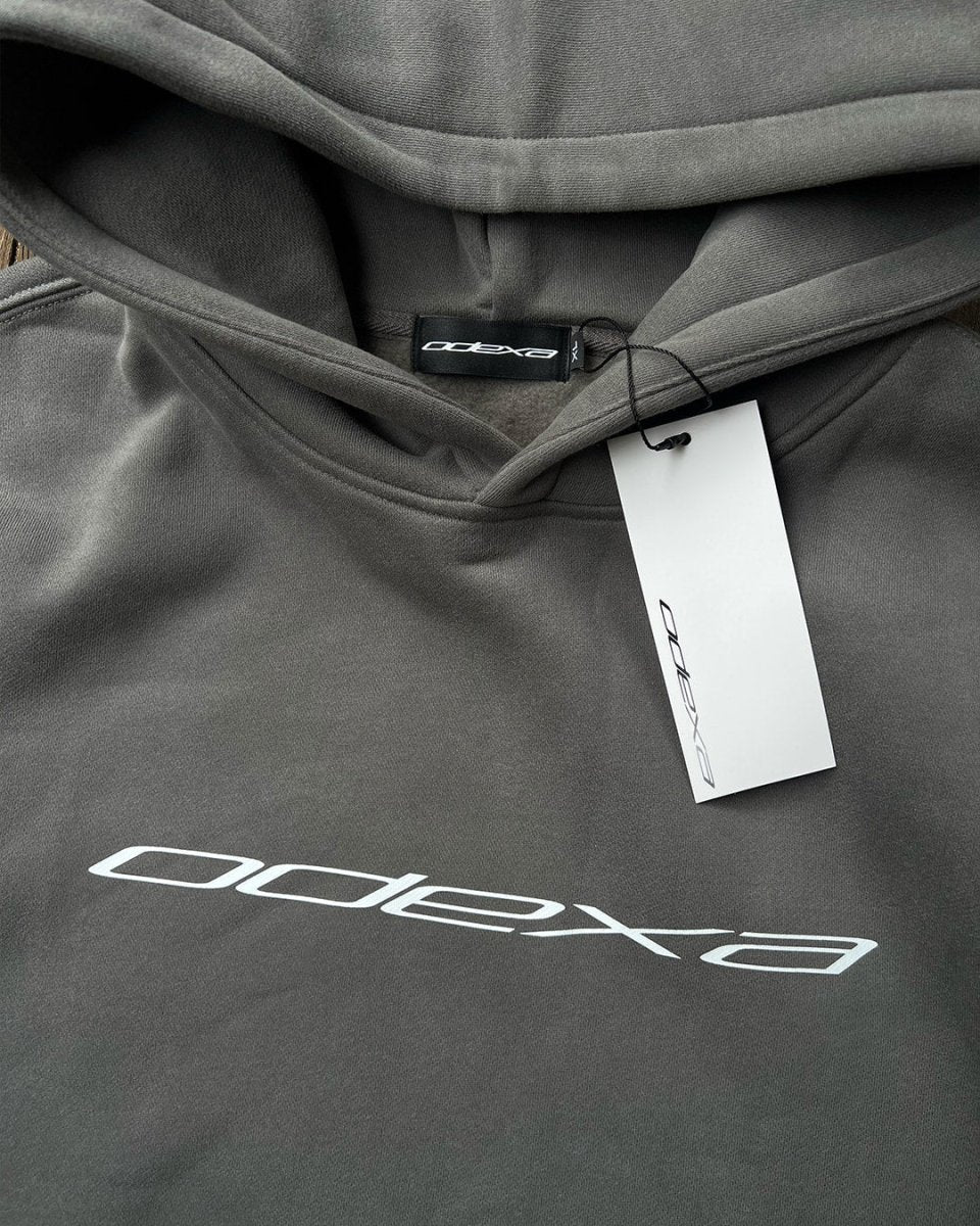 Close-up of grey hoodie hood and ODEXA logo with tag
