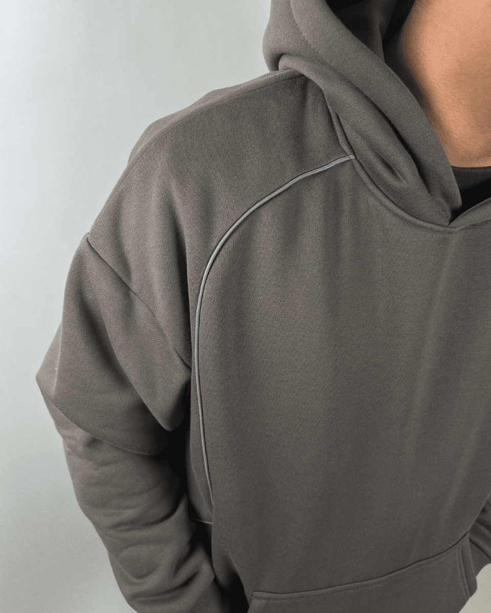 Model wearing charcoal Accented Reflective hoodie, side view