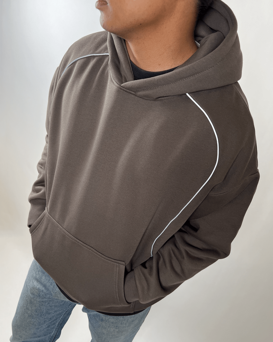 Model wearing charcoal Accented Reflective hoodie with reflective piping