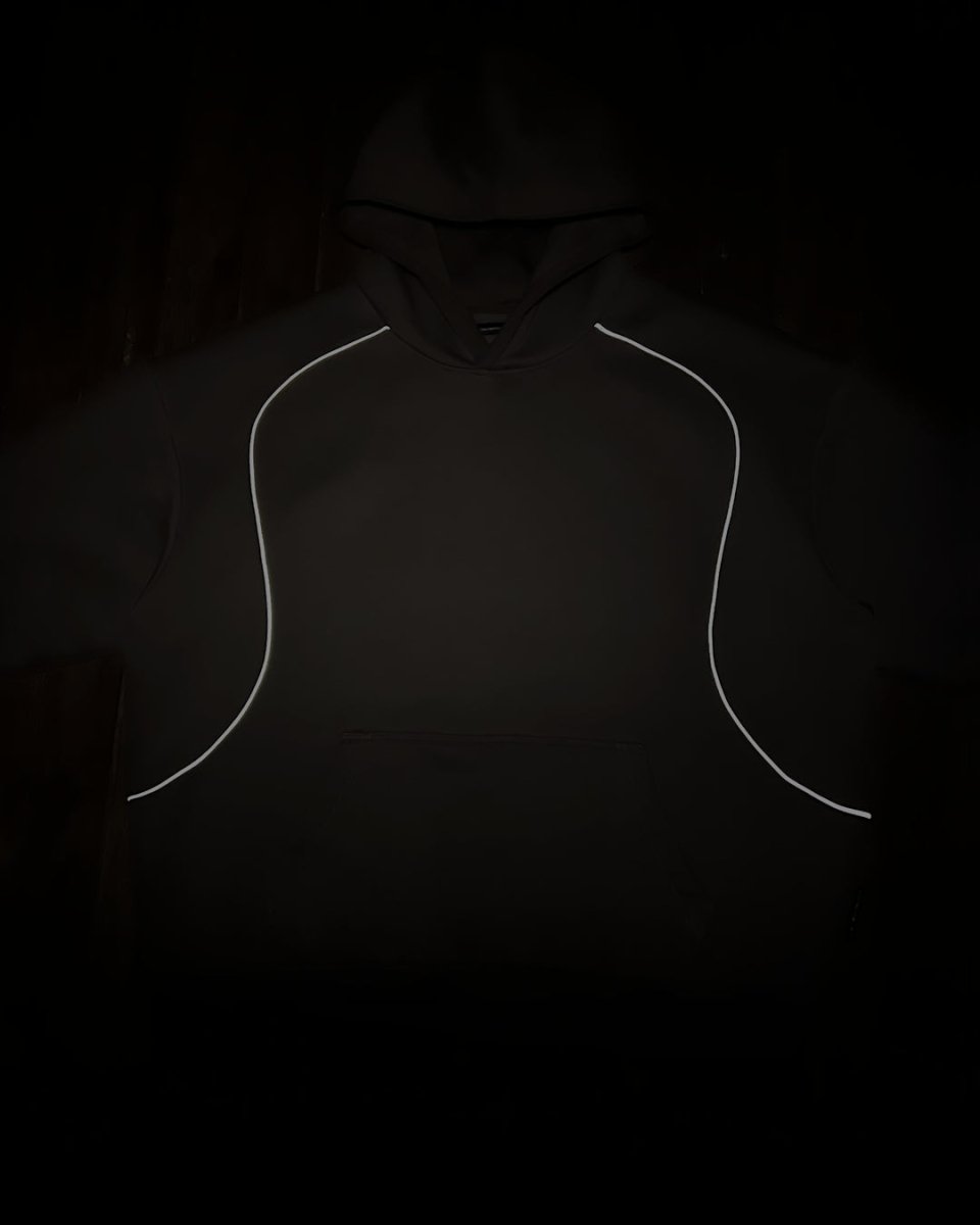 Charcoal hoodie with reflective piping glowing in the dark