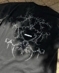 Washed black vintage tee with white tribal bone back print, flat lay