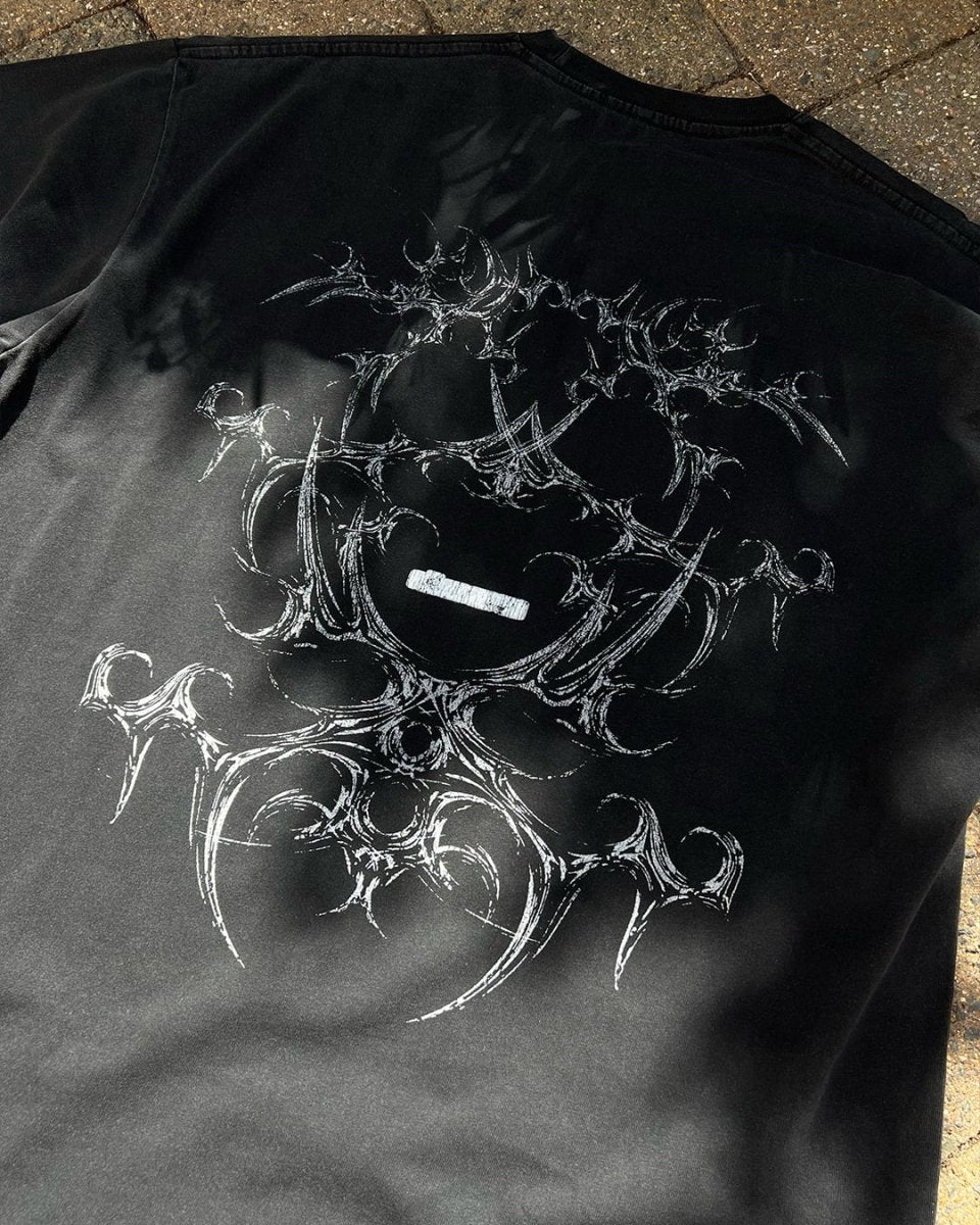 Washed black vintage tee with white tribal bone back print, flat lay