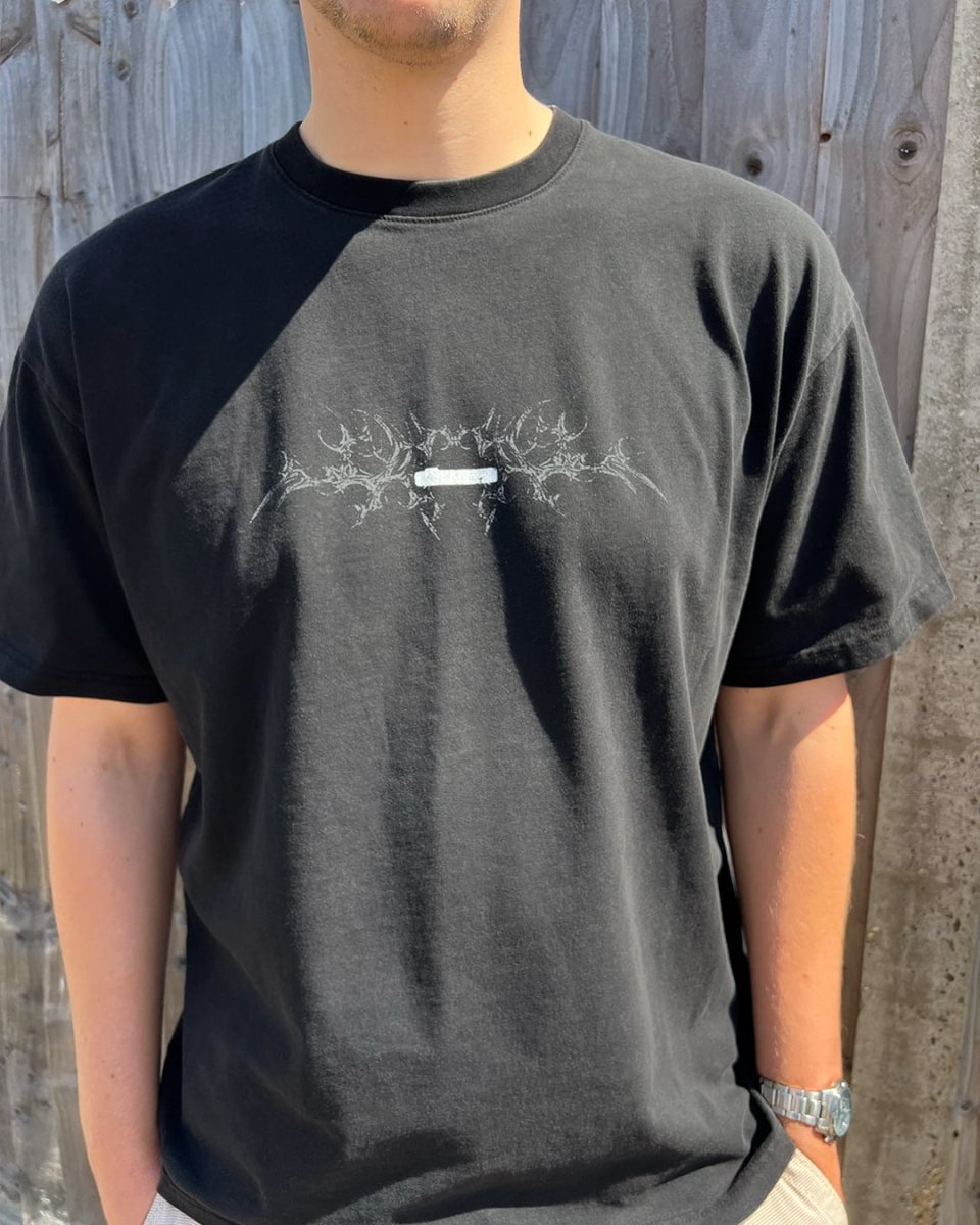 Model wearing washed black Black Bone vintage tee, front view