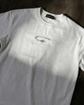 White vintage tee with small grey star chest print, flat lay