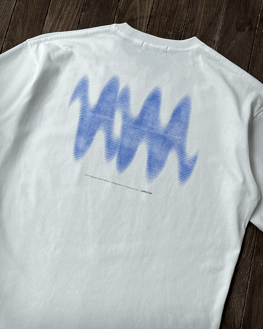 White vintage tee with blue wave back print, flat lay