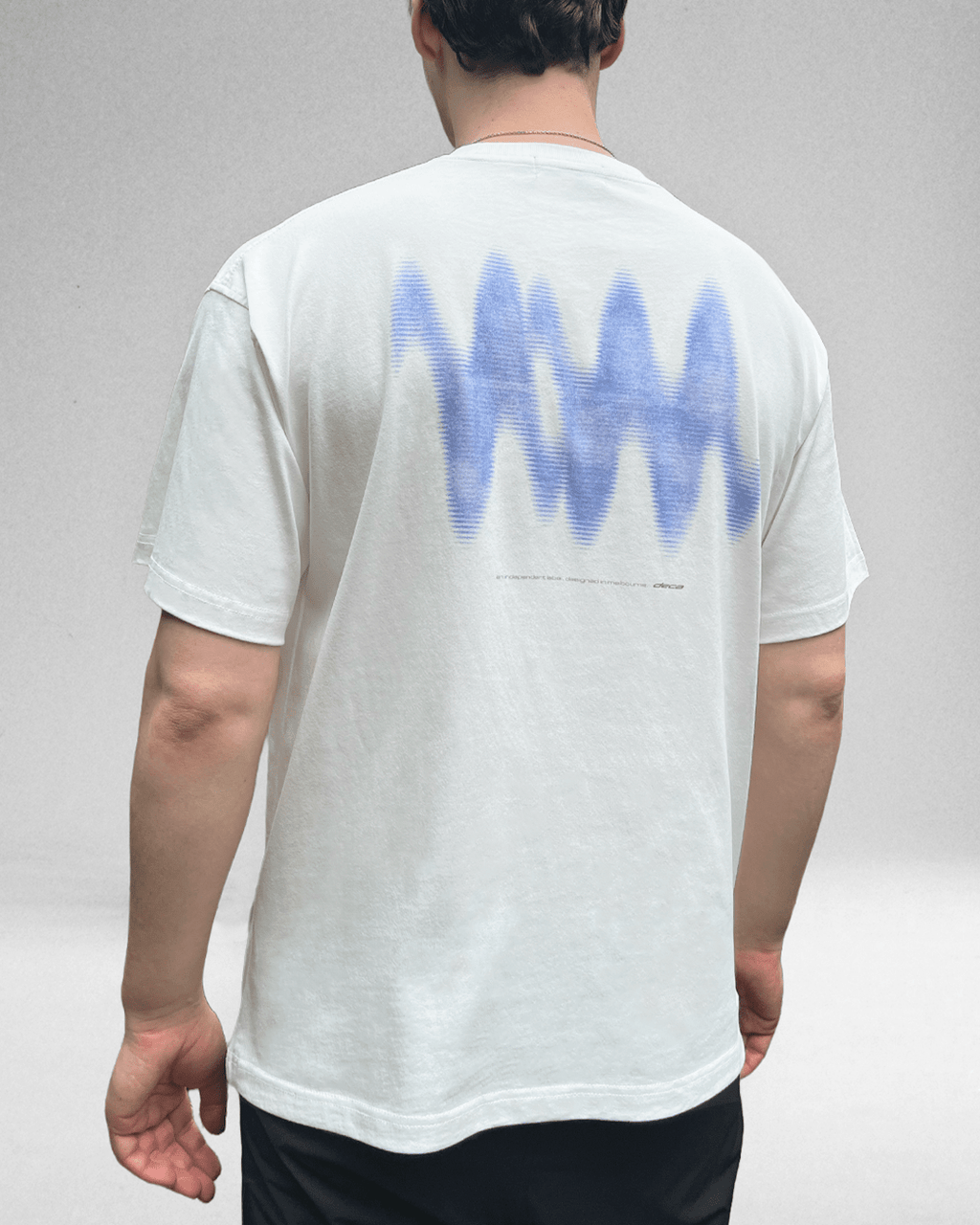 Model wearing white Blue Wave vintage tee, back view with blue wave print
