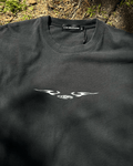 Washed black vintage tee with chrome sigil wing print, flat lay