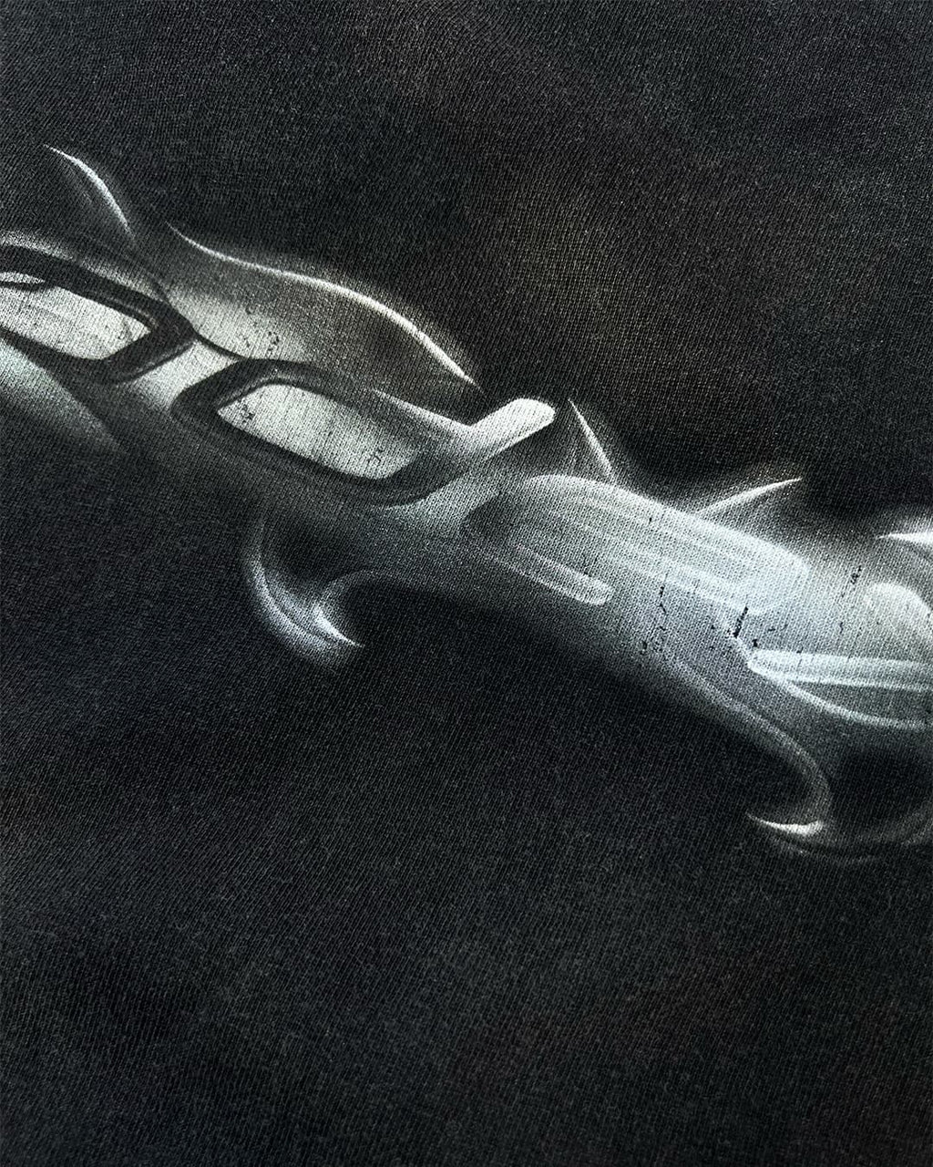 Close-up of chrome tribal ODEXA logo print