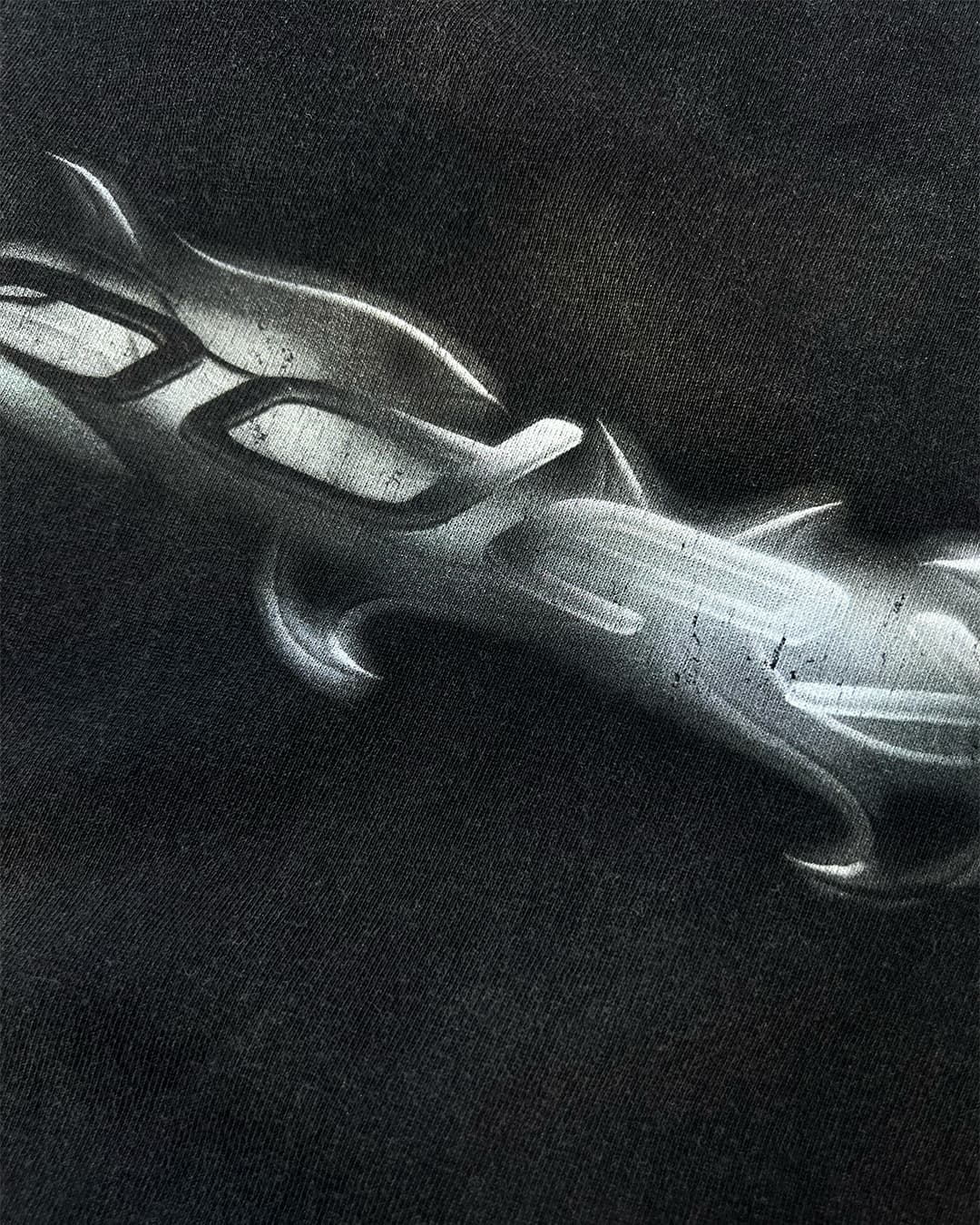 Close-up of chrome tribal ODEXA logo print