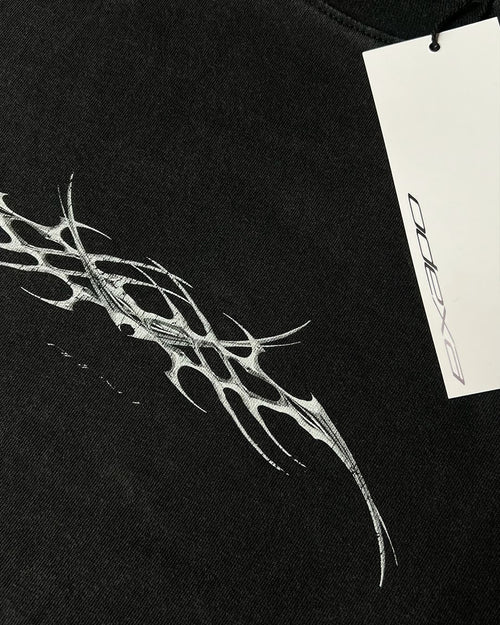 Close-up of chrome tribal sigil print on black vintage tee
