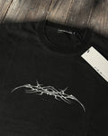 Washed black vintage tee with chrome tribal sigil print, flat lay