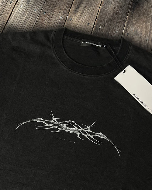 Washed black vintage tee with chrome tribal sigil print, flat lay