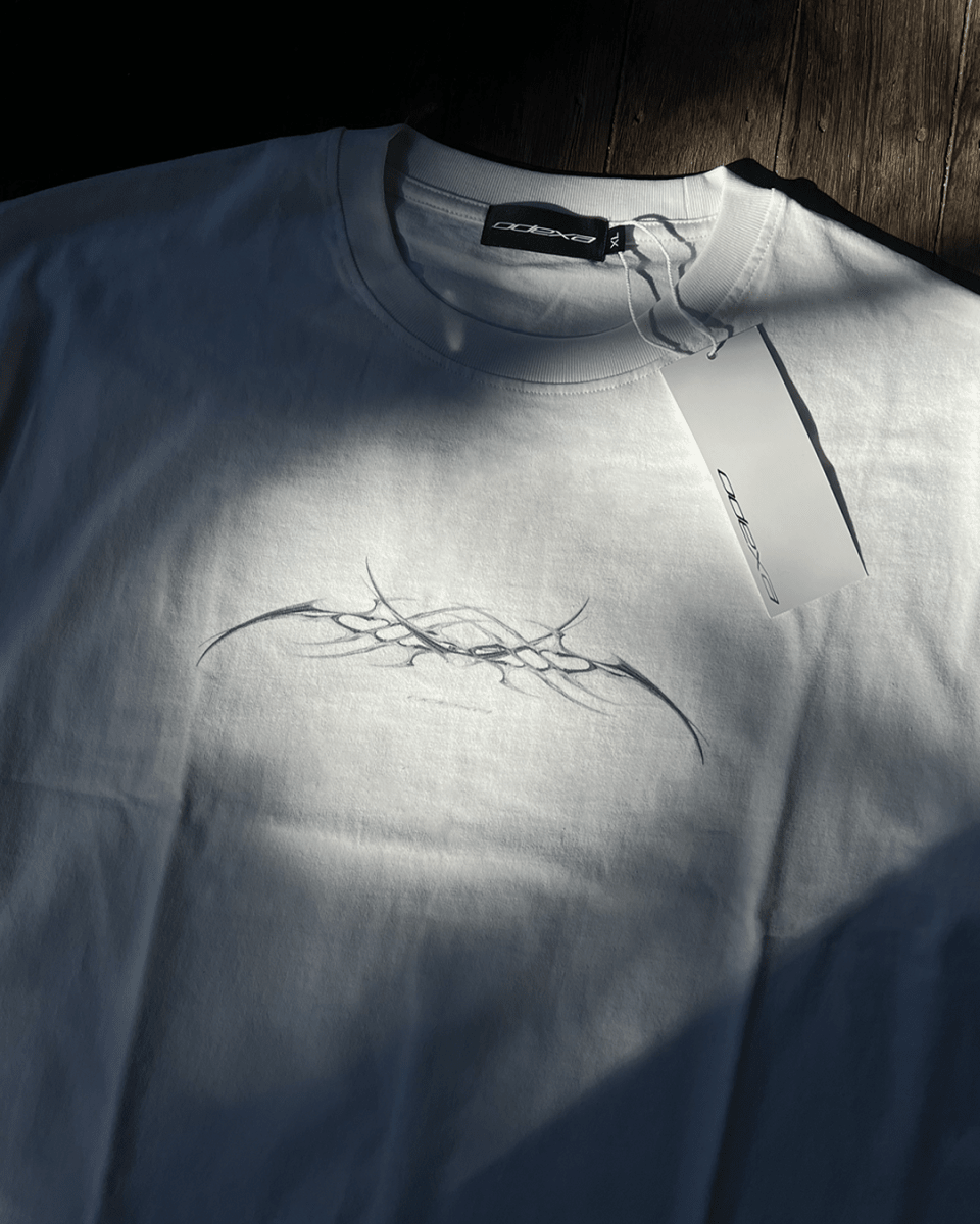 White vintage tee with black chrome sigil print, sunlit flat lay