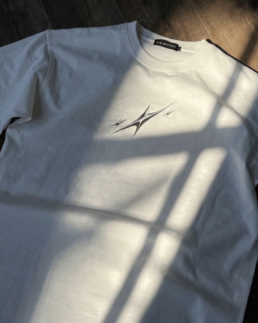 White Chrome Stars vintage tee in window light, flat lay