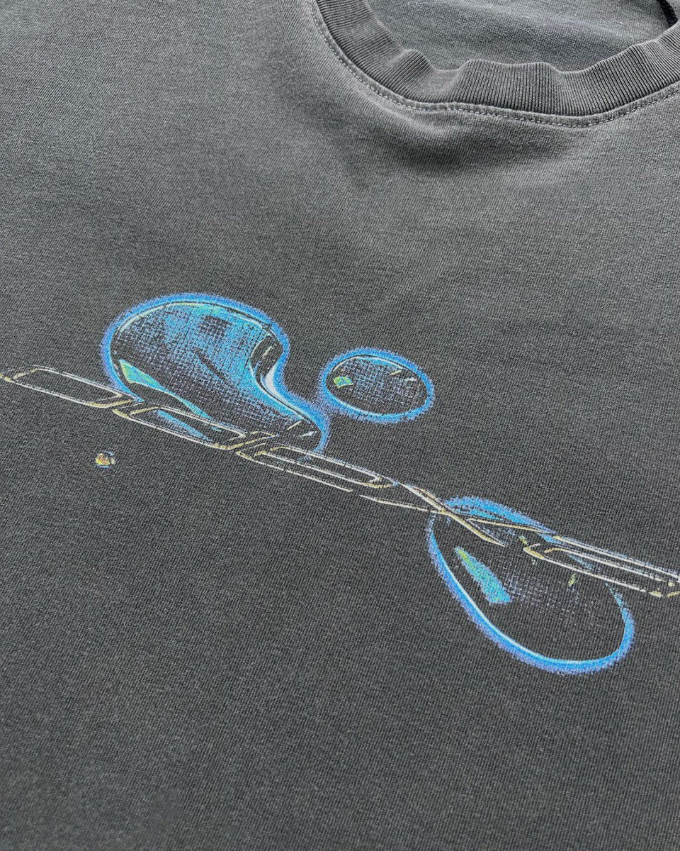 Close-up of blue liquid comic ODEXA logo print