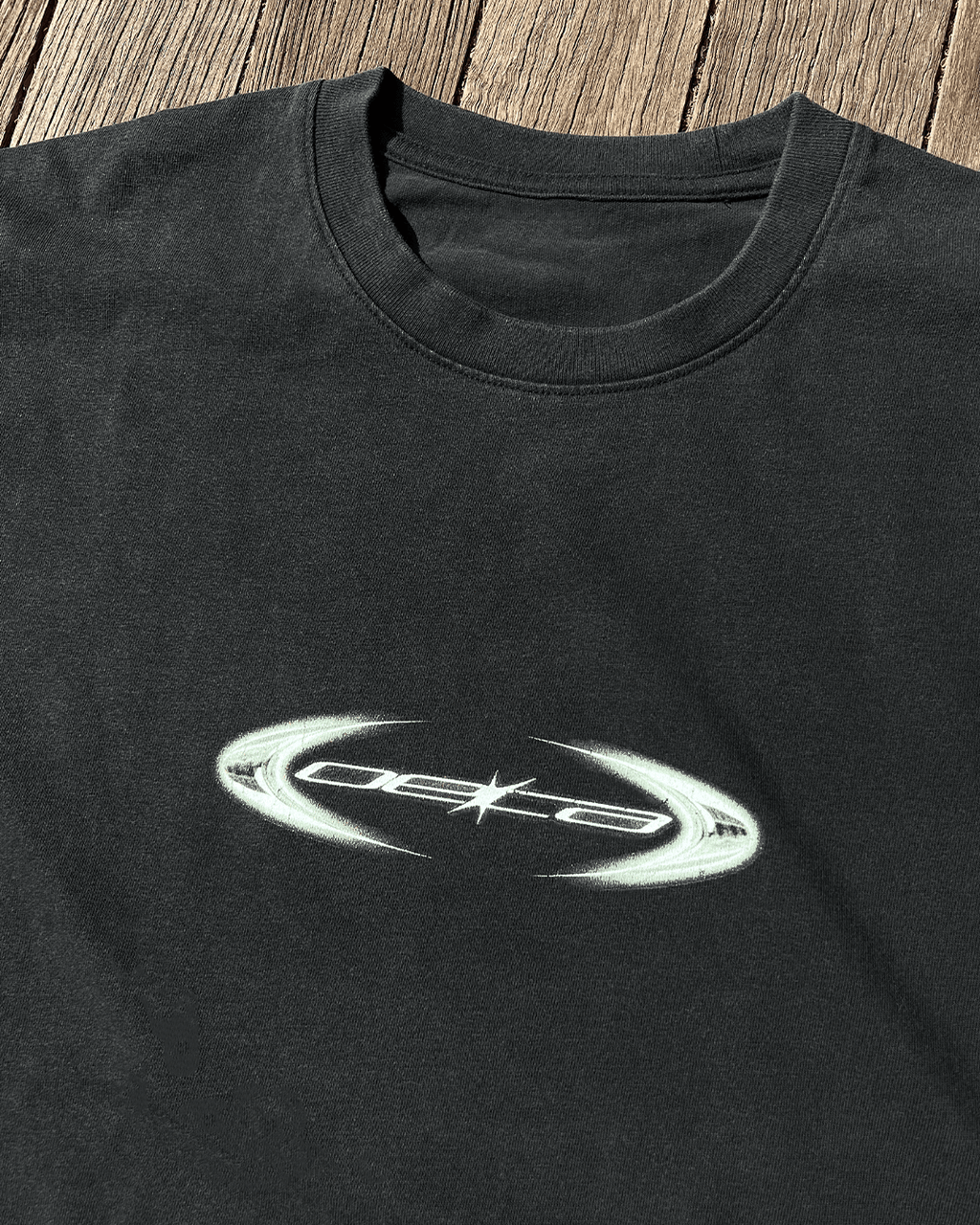 Close-up of copper oval logo print on black vintage tee
