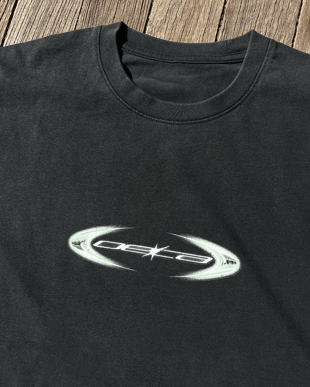 Close-up of copper oval logo print on black vintage tee
