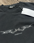 Washed black vintage tee with silver chrome tribal sigil print, angled view