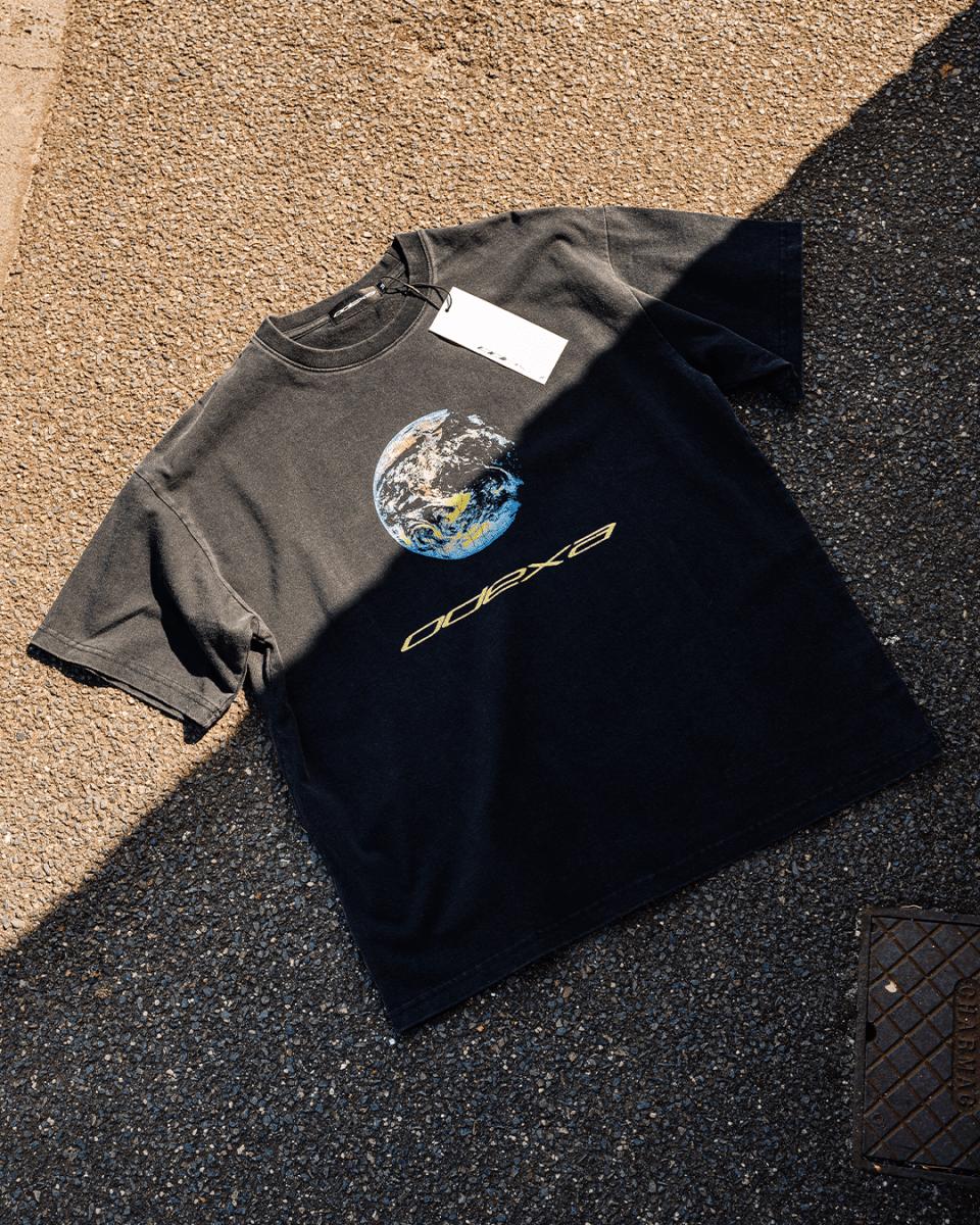 Washed black Earth 1 vintage tee in sunlight, flat lay