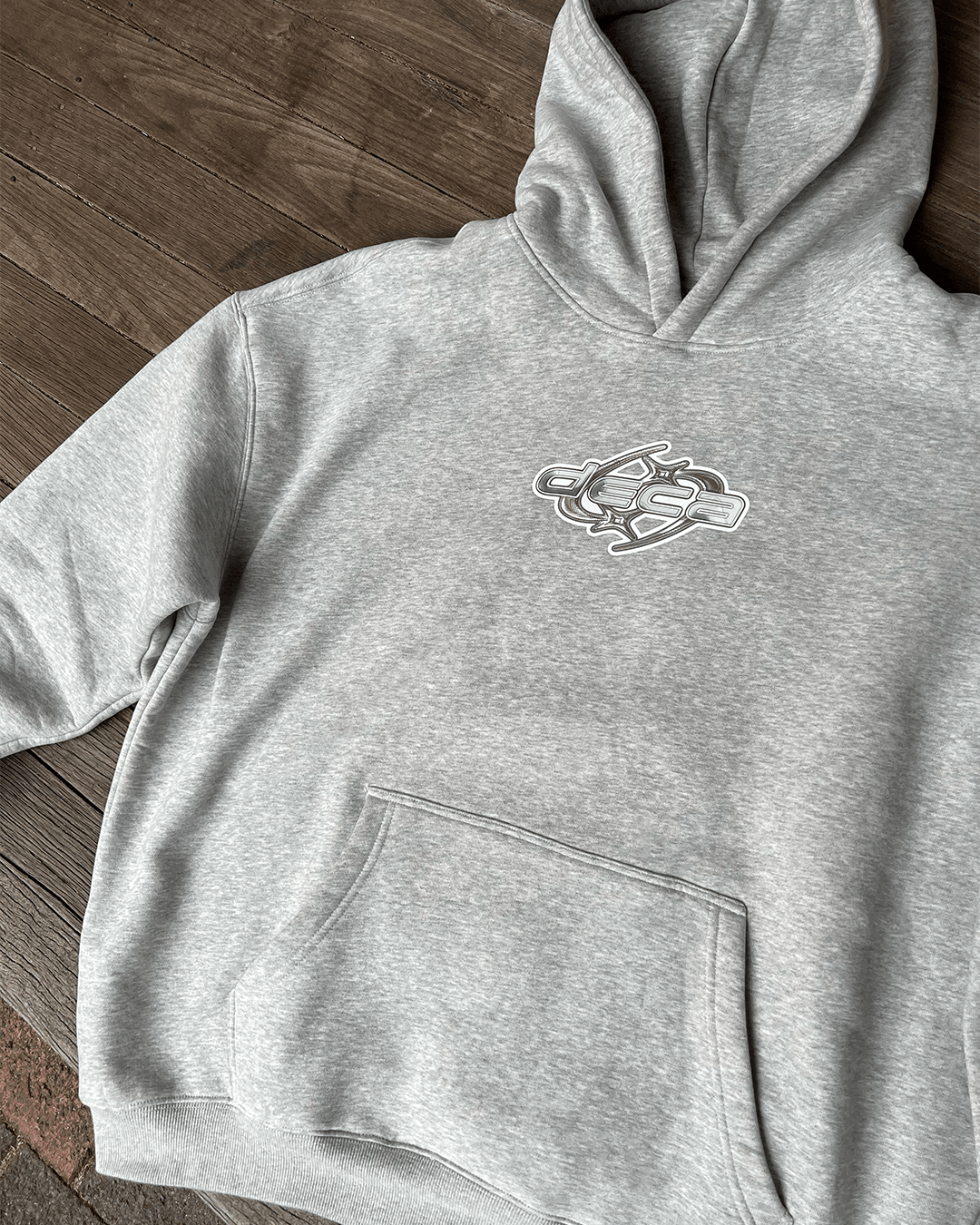 Heather grey oversized hoodie with white star logo chest print, flat lay