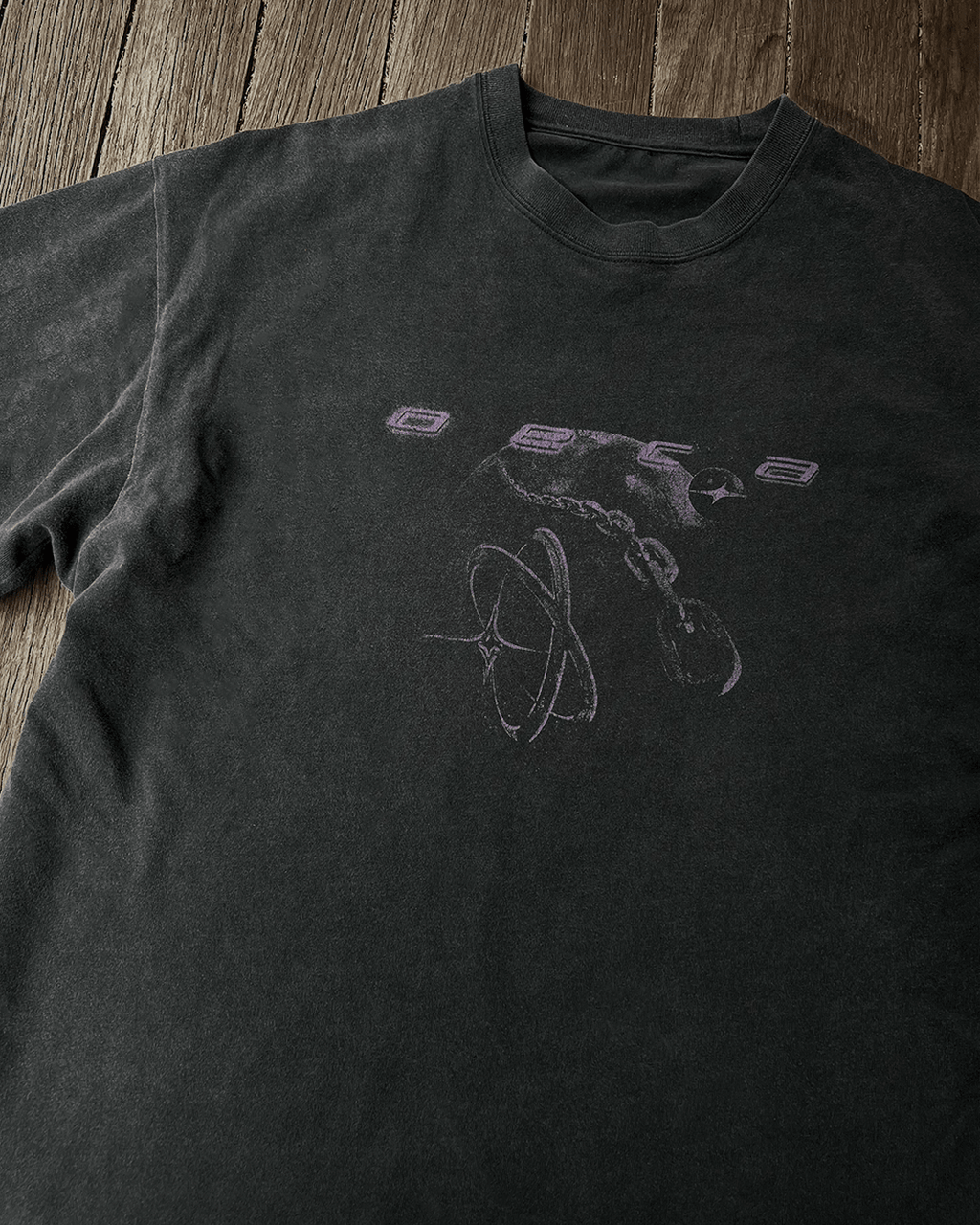Washed black vintage tee with tonal grunge planet print, flat lay