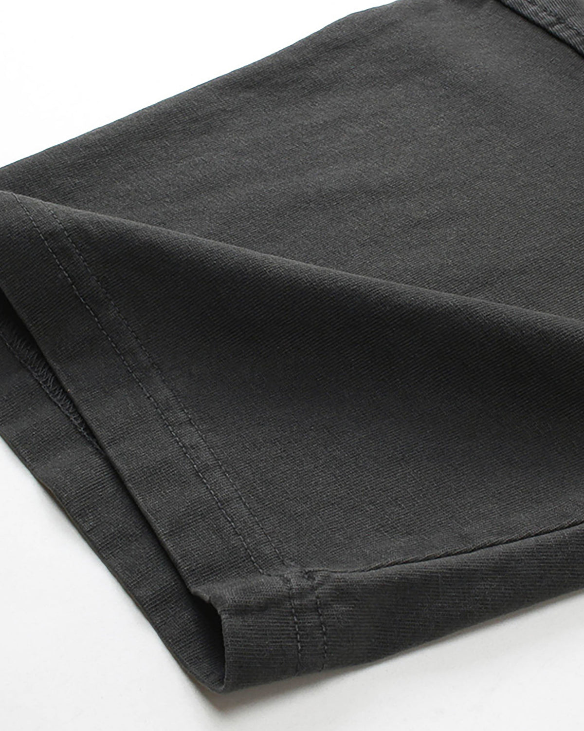 Close-up of folded sleeve cuff on washed black vintage tee showing fabric texture