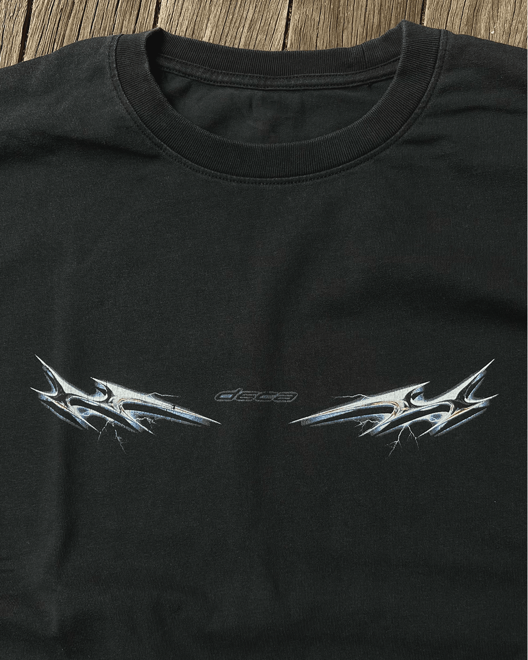 Black vintage tee with chrome lightning tribal print, flat lay