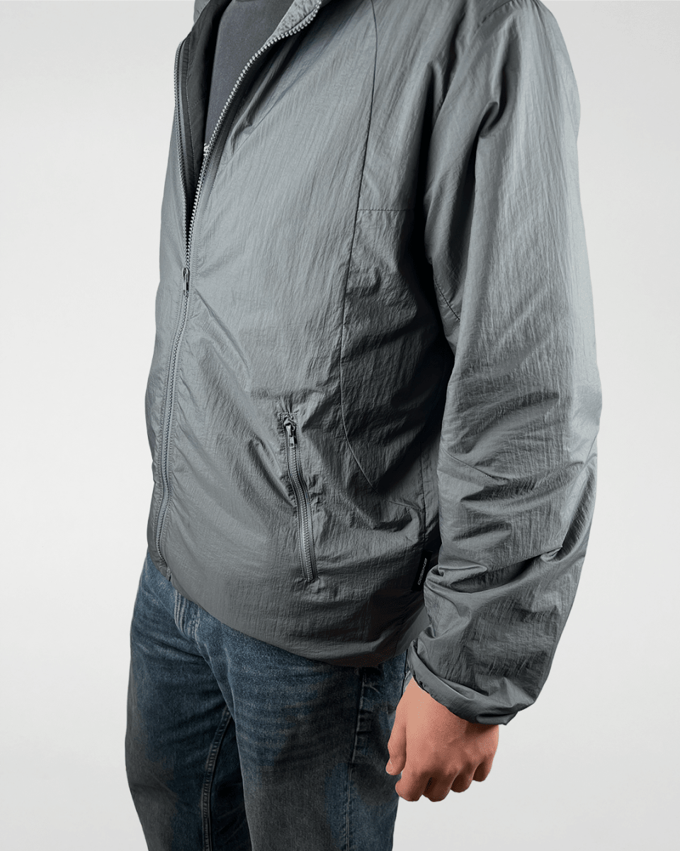 Model wearing slate green windbreaker jacket, side view