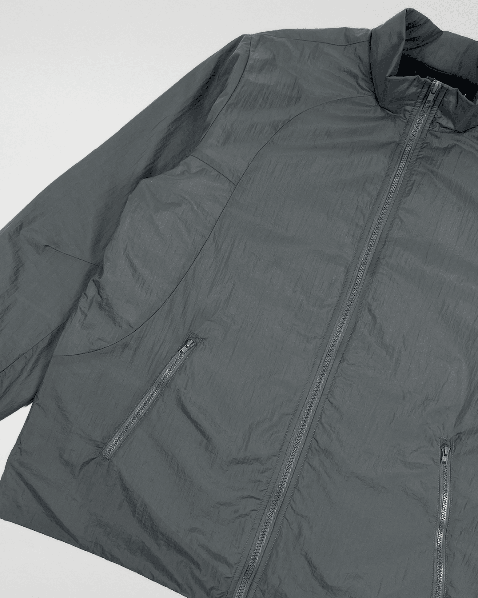 Close-up of slate green windbreaker front zip and pocket