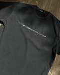 Washed black vintage tee with diagonal chrome logo print, flat lay