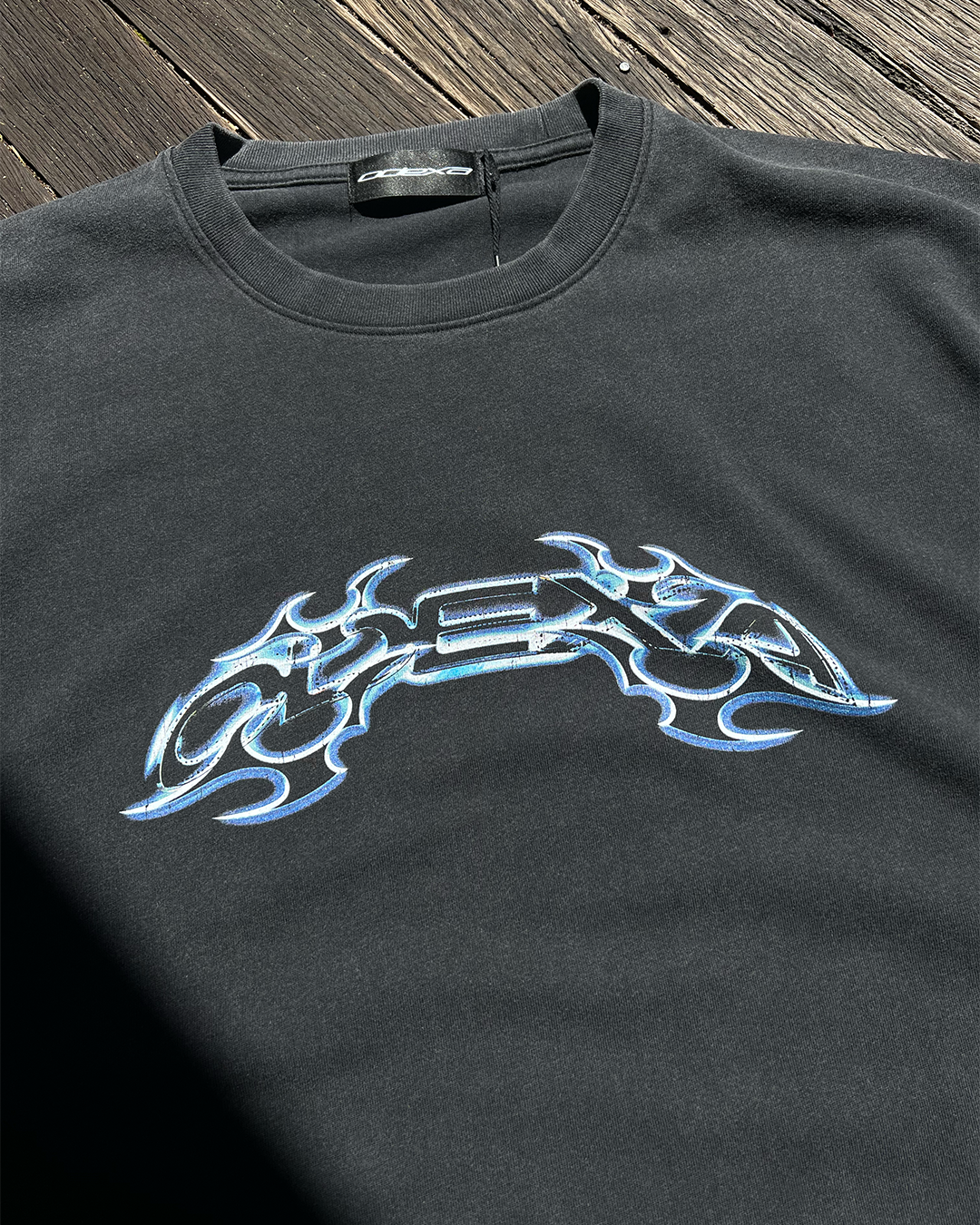 Washed black vintage tee with blue chrome tribal ODEXA print, front view