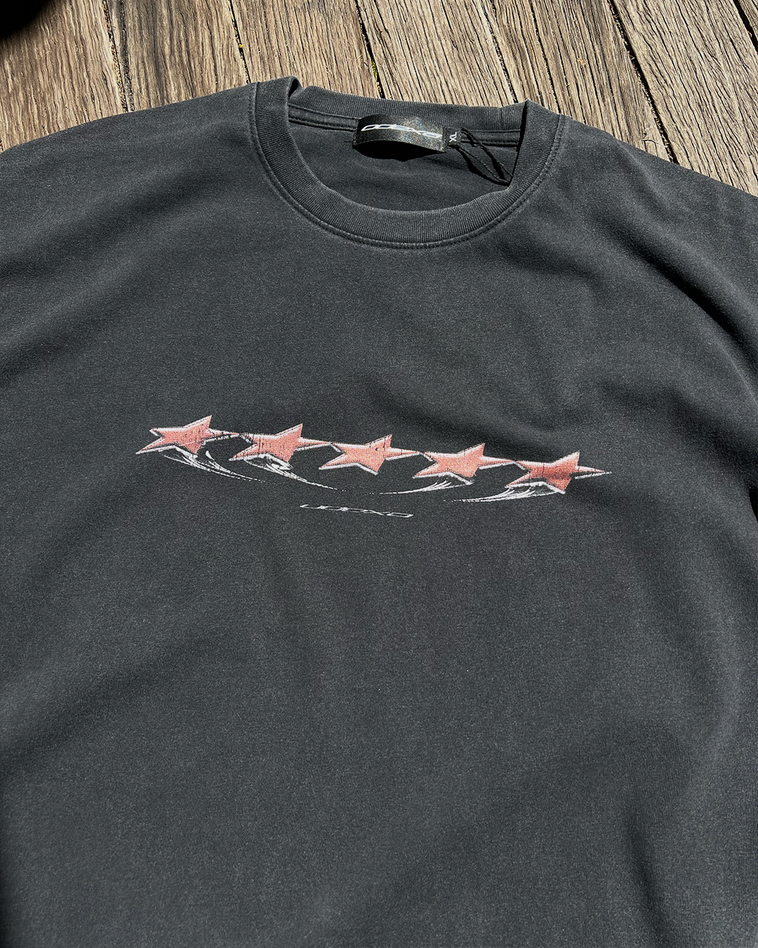 Washed black vintage tee with red stars chest print, front view