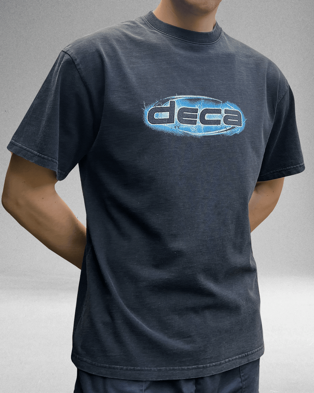 Model wearing washed navy Shock Logo vintage tee with blue chrome DECA logo
