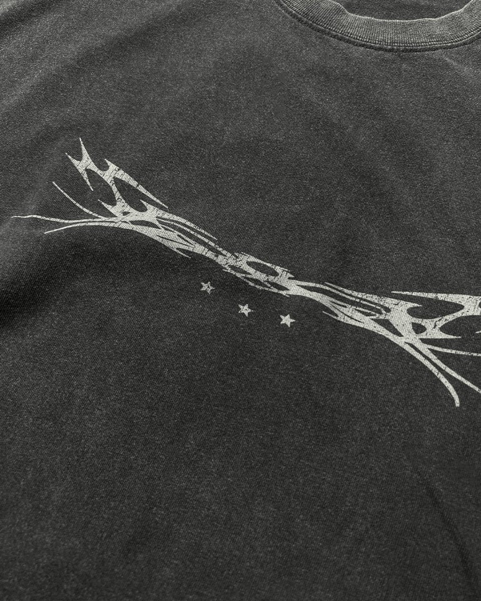 Close-up of chrome tribal sigil and stars print on black tee