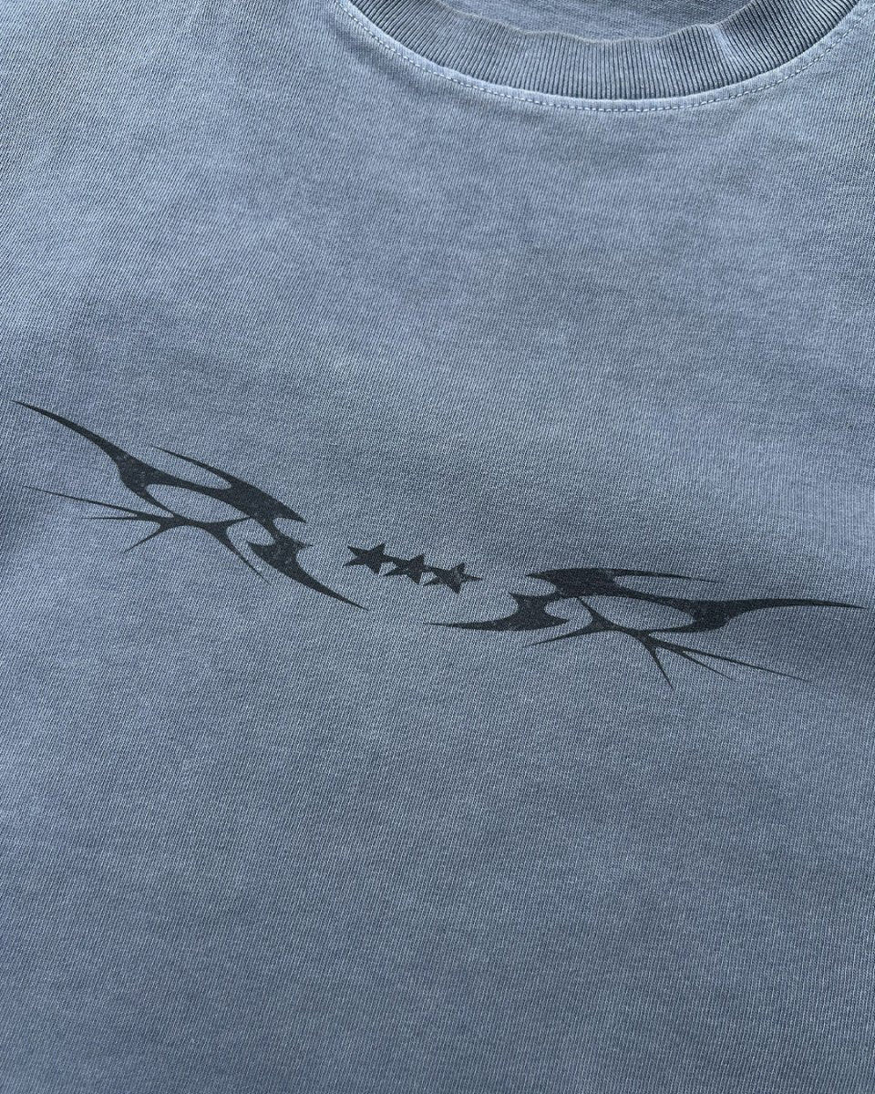 Close-up of black star sigil print on washed blue vintage tee