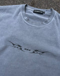 Washed blue vintage tee with black tribal star sigil print, flat lay