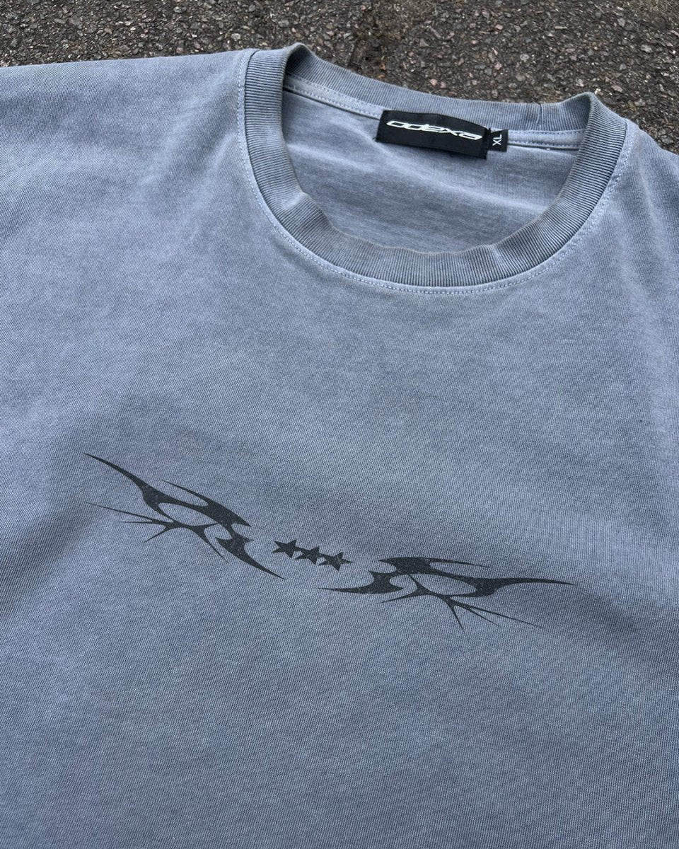 Washed blue vintage tee with black tribal star sigil print, flat lay