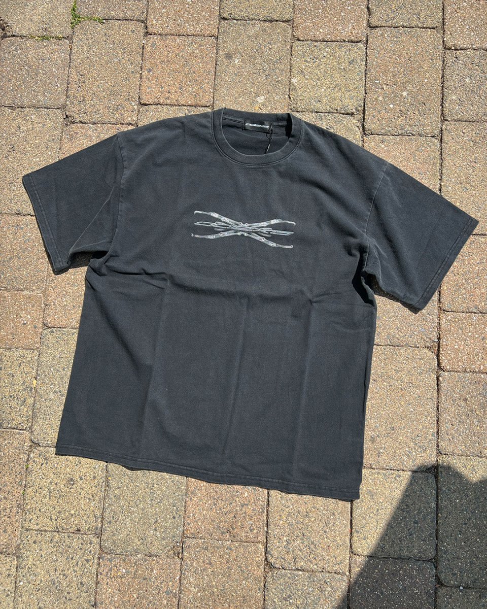 Washed black Tech Logo vintage tee on brick paving, flat lay