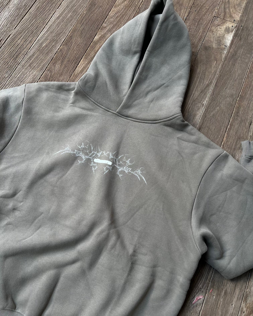 Moss grey boxy hoodie with small white chest print, front flat lay