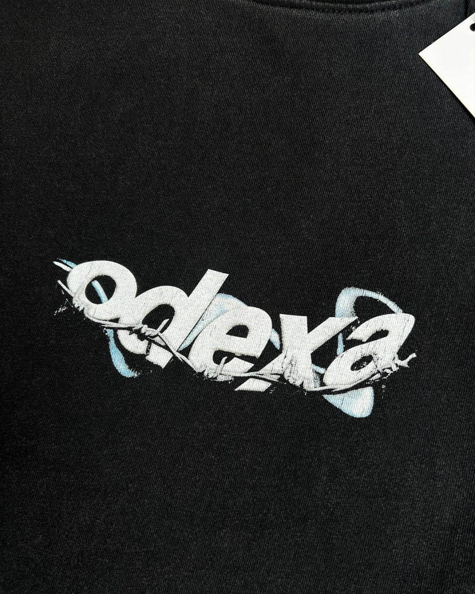 Close-up of white wire ODEXA logo print on black vintage tee