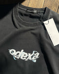 Washed black vintage tee with white wire ODEXA logo, flat lay